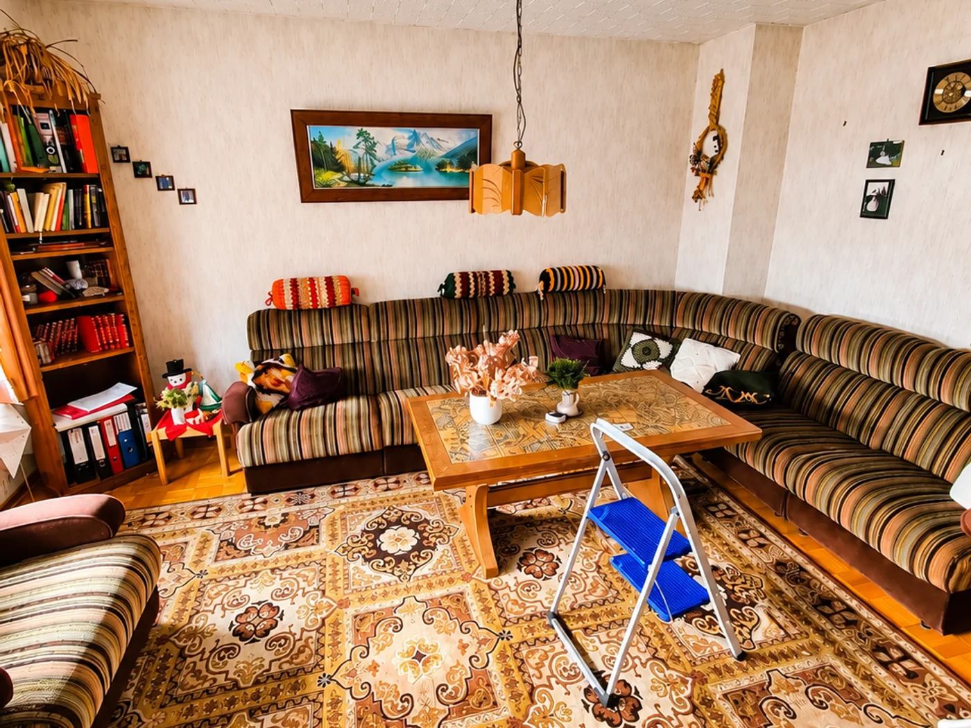 Gemütliches Retro-Wohnzimmer mit Möbeln und Stehleiter – Zustand vor der Entrümpelung
